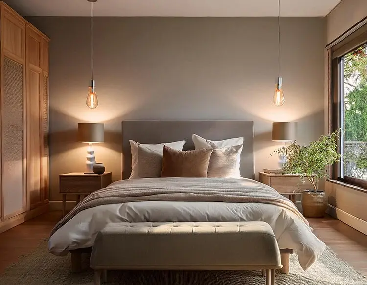 Quarto harmonizado com porta do banheiro fechada, iluminação suave e decoração minimalista